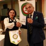 il Delegato consegna il guidoncino a Simona, titolare del ristorante